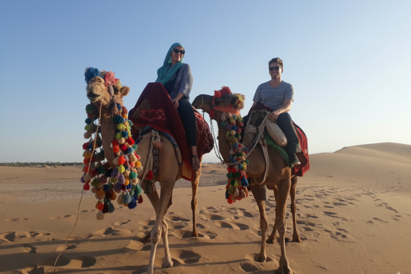 Tourists riding camels across golden dunes in Bafgh Desert, Yazd Province, Iran desert